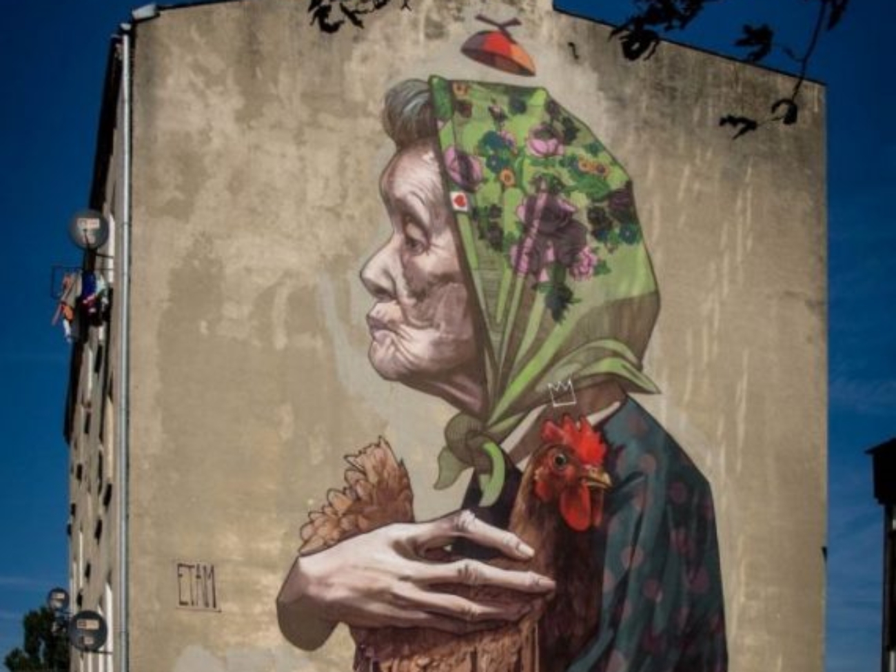 Łódzki mural - Kobieta z kurczakiem. Autor ETAM CREW