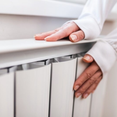 heavy-duty-radiator-central-heating-woman-is-getting-her-hands-warm-on-home-central-heating-system-min