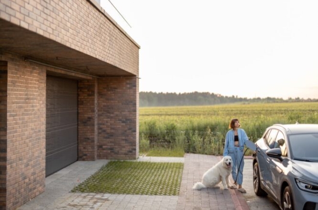 kobieta ładuje auto elektryczne przy domu